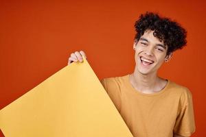 guy with curly hair yellow poster in hands studio advertising Copy Space photo