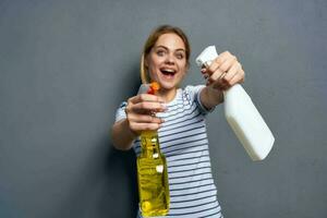 Woman striped t-shirt detergent cleaning housework gray background photo