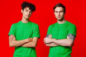 two friends green t-shirts fun red background communication photo