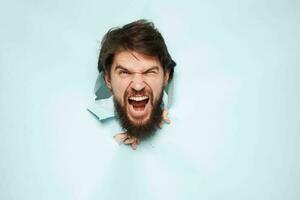 screaming bearded man peeking out from behind the wall emotions work photo