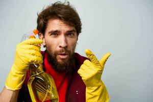 Man in yellow rubber gloves detergent housework rendering services close-up photo