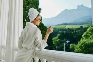 Woman in a bathrobe with patches on his face admires nature Lifestyle photo