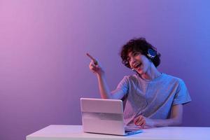 hombre en auriculares en frente de ordenador portátil entretenimiento aislado antecedentes foto