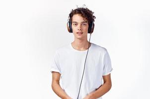 un hombre en un blanco camiseta con auriculares escucha a música emociones alegría disfrute foto