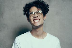 man with glasses curly hair white t-shirt studio emotion photo
