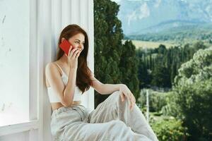 beautiful woman with a red phone Terrace outdoor luxury landscape leisure Perfect sunny morning photo