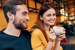 retrato de un hombre en un suéter y un mujer con un taza de café interior habitación foto