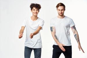 dos gracioso amigos en blanco camisetas riendo positivo emociones foto