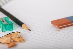 Pencils, eraser school image and back classes - Pencil, eraser and pointed on a sheet of notebook photo