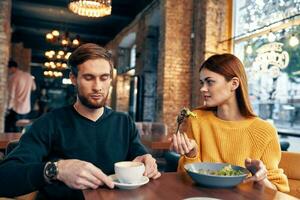 woman and man dining in restaurant salad meal food cup of coffee photo