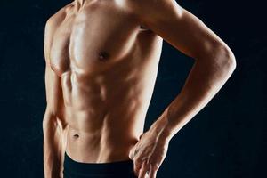 sporty man with a pumped-up muscular body in a towel dark background photo