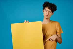 guy in yellow t-shirt poster mockup advertising blue background photo