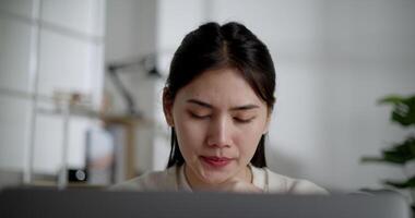 Locked shot, Portrait thoughtful Young woman look at display with stress while working on computer laptop at home video