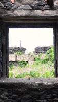View through abandoned stone house window into grassy meadow video