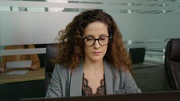 Concentrated businesswoman working online on computer at office. video