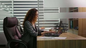 lato Visualizza donne collaboratori sedersi a ufficio Lavorando su il computer portatile. video