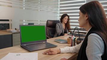 Office workers engaged in a project one watching a green screen laptop. video