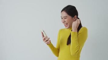 Asian beautiful woman exited surprise face expression . female feels shocked with the phone. exciting smile and happy adorable rejoices. Very enjoy and fun relax time. wow, girl holding smartphone. video