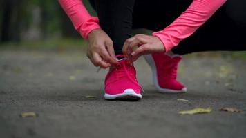 vicino su di donna in esecuzione attraverso un autunno parco a tramonto video