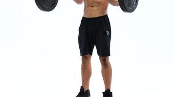 Man flexes his hands with dumbbells, training his shoulders on a white background in the studio video