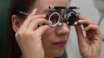 femme à le accueil de un ophtalmologiste. œil examen et sélection de spectacle lentilles video