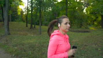 Close up of woman running through an autumn park at sunset video