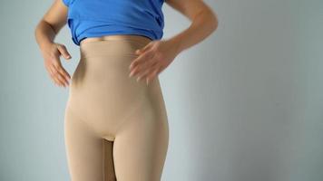 Frau im Abnehmen Unterhose rollen Nieder Kleid auf oben und prüft das Ergebnis. Konzept von Aspiration zum ein perfekt Körper video