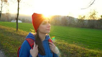 femme voyageur avec une sac à dos des promenades sur le route dans le campagne et admire le alentours paysage video