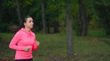 Close up of woman running through an autumn park at sunset video