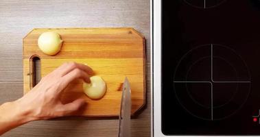 Technique of slicing onions on a wooden Board, top view. video