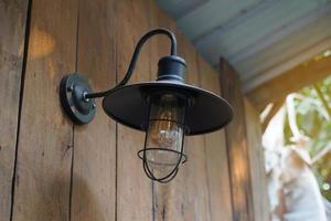 Wall lamp, American style retro pot lid design. Black, made of good quality steel. Install it outside the house for beauty and lighting at night. Soft and selective focus. photo