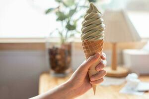 mano participación hielo crema cono, verde té hielo crema foto