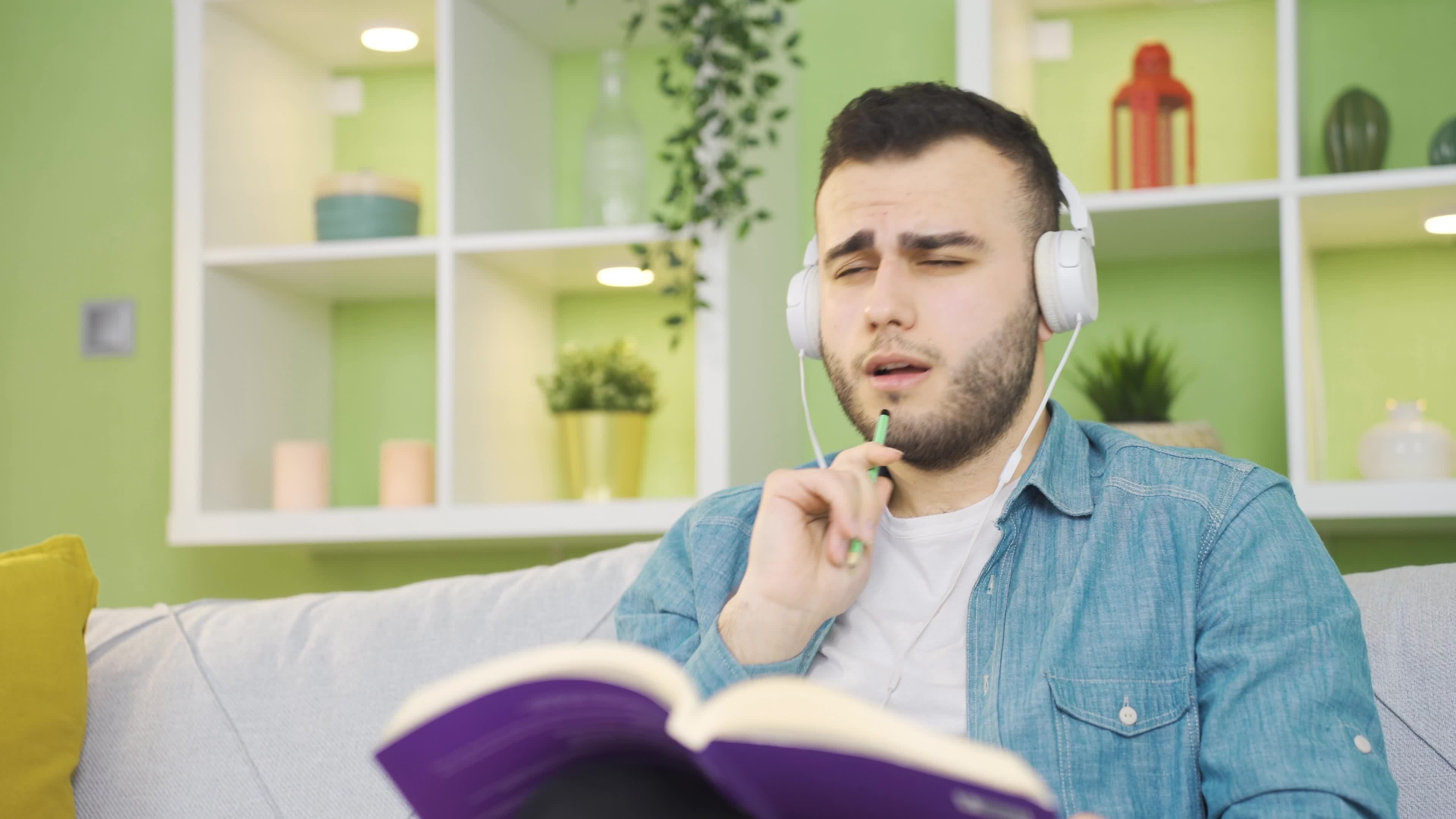 relaxing-peaceful-young-man-reading-a-book-listening-to-music-at-home