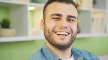 fermer portrait de positif homme avec souriant affronter. charmant et énergique homme à Accueil souriant et à la recherche à caméra. video