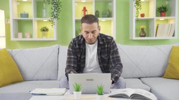 Bored depressed man is overwhelmed and stressed from home. Man working with laptop at home feeling overwhelmed and bored. video