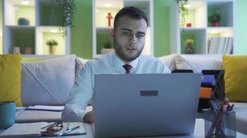 frustrato uomo d'affari triste a casa. uomo d'affari Lavorando a casa su il computer portatile prende frustrato e depresso. video