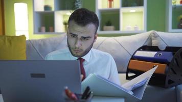 Geschäftsmann Arbeiten mit Laptop und Ordner im das Leben Zimmer. konzentriert und ernst Geschäftsmann suchen beim Laptop. video