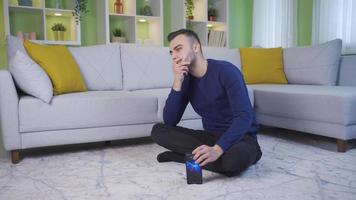 Depressed and unhappy man at home. Thoughtful, unhappiness man sitting alone on the floor at home. video