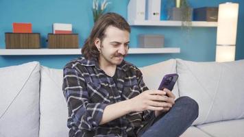 le homme qui trouve un idée tandis que en utilisant le téléphone. génial idée. le adolescent en utilisant le téléphone vient en haut avec un idée et est très heureux. le idée est super. video