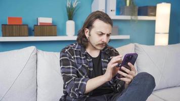 il giovane uomo chi è sorpreso e arrabbiato a che cosa lui vede su il Telefono. il uomo, chi è sorpreso e arrabbiato con che cosa lui vede su il Telefono, prende irritato e lanci il Telefono lontano. video