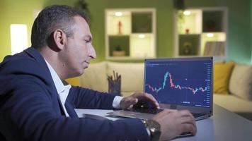 Online stock broker looking thoughtfully at the charts. Bitcoin and stock market trading concept. Man looking at charts of cryptocurrency exchanges on computer screen. video