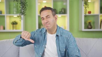 Negative man expresses liking at home. The man looking at the camera and expressing his dislike with a negative expression. video