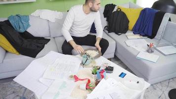 Lazy man eating in his messy and dirty house, looking at paperwork. Lazy businessman sitting in his messy and dirty house and bored. video