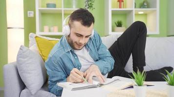 feliz jovem aluna estudando às casa agradável e Diversão. jovem uni aluna homem estudando às casa dentro uma relaxado e pacífico caminho, feliz. video