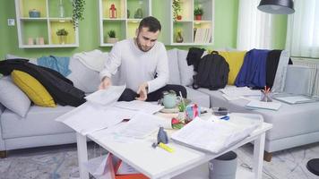 preguiçoso homem sofre a partir de desordem às lar. preguiçoso homem olhando às papéis às lar, procurando dentro bagunça. video