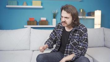 psychologique problèmes, folie. Jeune homme avec psychologique problèmes parlant à lui-même à maison. Etat de folie. video