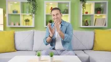 Bravo, clapping man congrats, rejoicing and proud. Man sitting on sofa at home giving support by applauding, offering congratulations. video