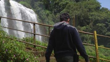 The man walking on the waterfall destination on Semarang Central Java. The photo is suitable to use for adventure content media, nature poster and forest background. video