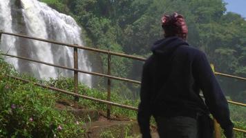 The man walking on the waterfall destination on Semarang Central Java. The photo is suitable to use for adventure content media, nature poster and forest background. video