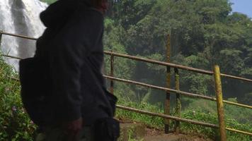 The man walking on the waterfall destination on Semarang Central Java. The photo is suitable to use for adventure content media, nature poster and forest background. video